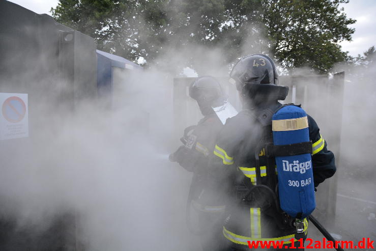 Brand i tøj container.